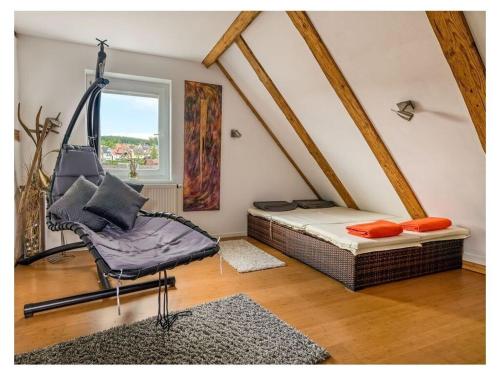 a attic room with a bed and a swing at Romantic maisonette in Schonach