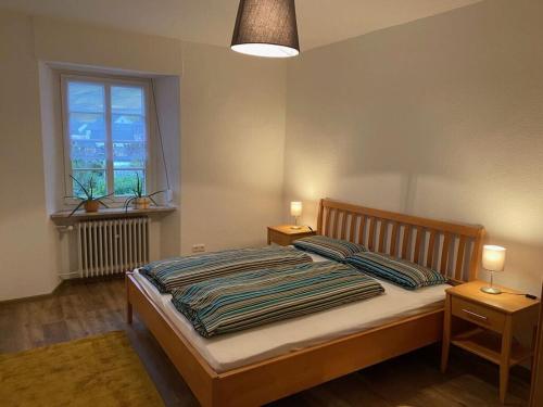 een slaapkamer met een bed met 2 nachtkastjes en een raam bij Wingertsblick Modern retreat in Graach