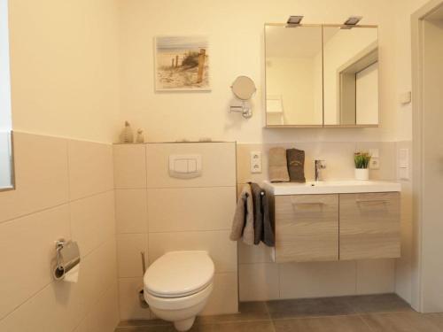 a white bathroom with a toilet and a sink at Marinapark 147 Modern retreat in Walchum