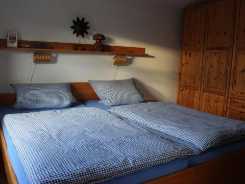 a bedroom with a bed with a blue comforter at Barbara Hintermair in Bischofsmais