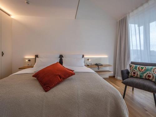 ein Schlafzimmer mit einem großen Bett mit einem roten Kissen darauf in der Unterkunft Suite apartment 80 sqm in Gundholzen