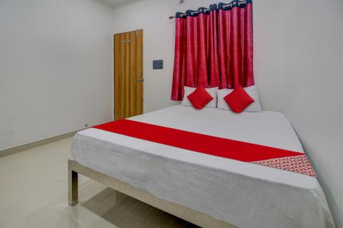 1 dormitorio con 1 cama grande y cortinas rojas en OYO Flagship Hotel Roman Inn en Nagpur