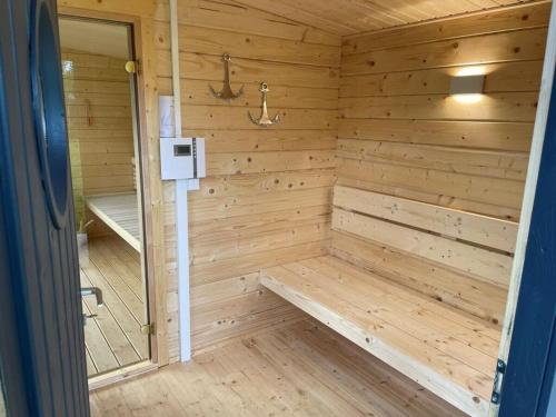 a wooden sauna with a bench in it at Lovely holiday home with sauna in Hooksiel