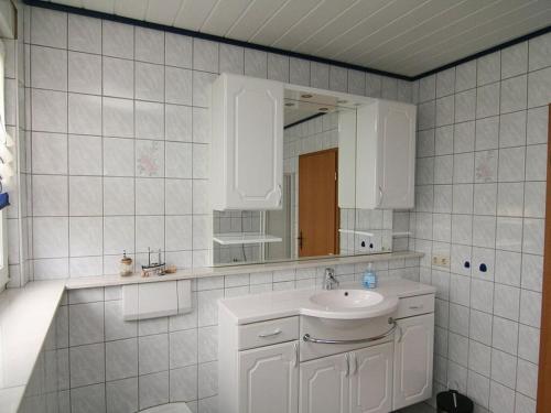 a white bathroom with a sink and a mirror at Am Turm Modern retreat in Mellrichstadt
