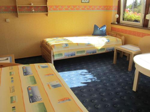 een kleine kamer met 2 bedden en een tafel bij Rose ambience Modern retreat in Bad Langensalza