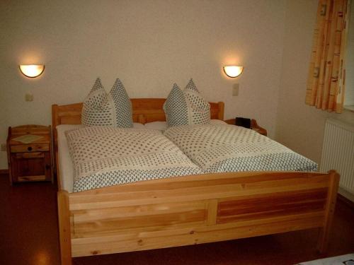 a bedroom with a wooden bed with two pillows at Breitenbach Modern retreat in Harbshausen
