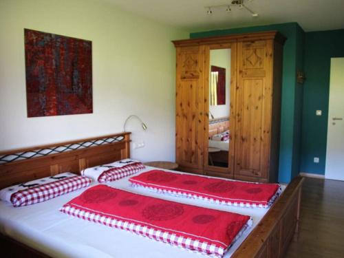 una camera con due letti con cuscini rossi e bianchi di Hochgrat view in Steibis, Haus Akelei a Steibis