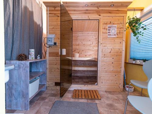 a bathroom with a shower with a wooden wall at "Schmiedegässchen" Comfortable holiday residence in Kamp-Bornhofen