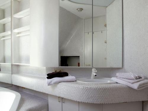 ein weißes Badezimmer mit Waschbecken und Spiegel in der Unterkunft Hermitage-Dahn Modern retreat in Dahn