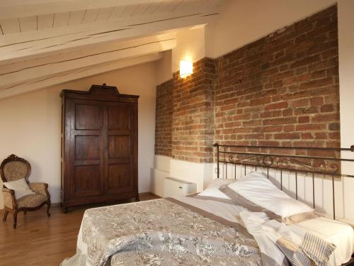 a bedroom with a brick wall and a bed at Relais Palazzo Paleologi Sec.XIV in Lu