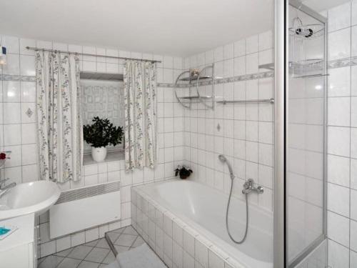 Baño blanco con bañera y lavamanos en Rachelblick Modern retreat en Untermitterdorf