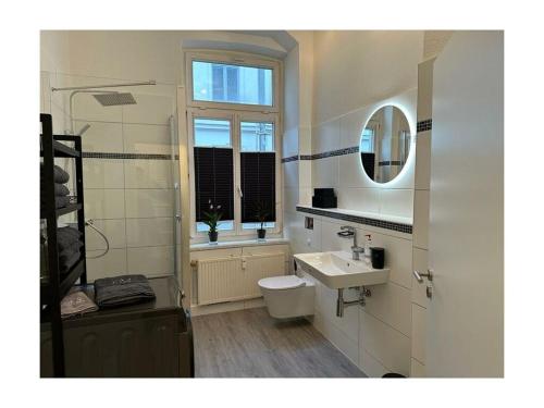 ein Bad mit einem Waschbecken, einem WC und einem Fenster in der Unterkunft Family apartment at Pfaffenteich in Schwerin