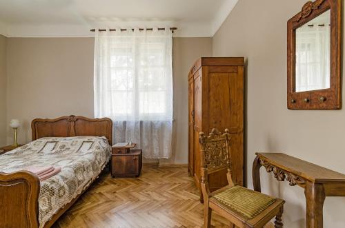 sypialnia z łóżkiem, lustrem i krzesłem w obiekcie Апартамент Гардения w Warnie