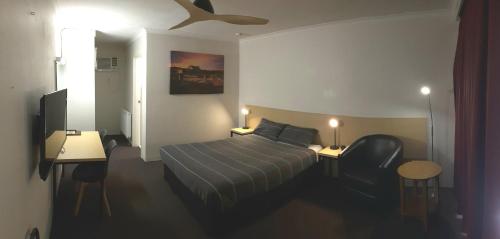 um quarto de hotel com uma cama e um tecto em Cooma Motor Lodge Motel em Cooma