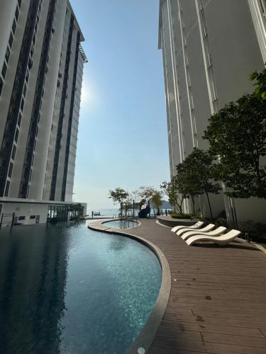 a swimming pool in between two tall buildings at The Shore by MD Staycation in Kota Kinabalu