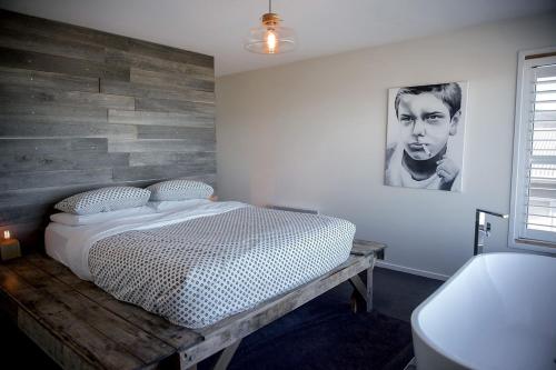 a bedroom with a bed and a wooden wall at Couples Getaway on Bruny Island in Alonnah