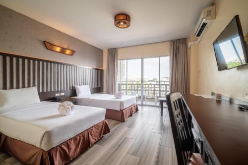 a hotel room with two beds and a balcony at J A Plus Hotel in Pattaya Central