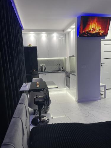 a kitchen with a couch and a table with a fireplace at MP Apartament 2 Białystok Jacuzzi in Białystok