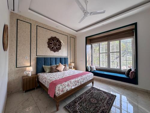 um quarto com uma cama e uma grande janela em The Chirpy Bungalow By LUHO Leisure em Dehradun