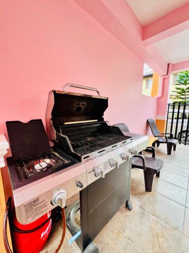 a grill in a room with a pink wall at Cara Transient house in San Pablo