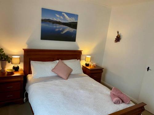 a bedroom with a bed with two tables and two lamps at Close to Town and Very Private in Myrtleford
