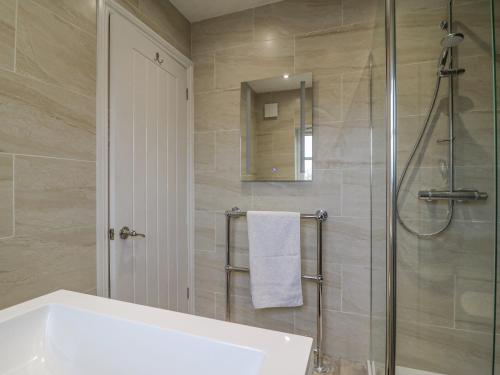 a bathroom with a shower and a sink and a mirror at Knapp Cottage in Weymouth