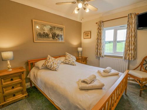 a bedroom with a bed with two towels on it at Knapp Cottage in Weymouth