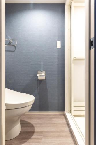 a bathroom with a toilet and a blue wall at 67 Apt Koenji Tokyo in Tokyo