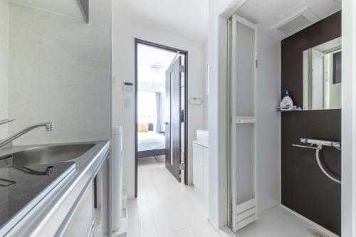 a white bathroom with a sink and a mirror at 67 Apt Koenji Tokyo in Tokyo