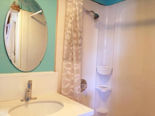 a bathroom with a sink and a mirror and a shower at A-Capital Hill Hideaway in Seattle