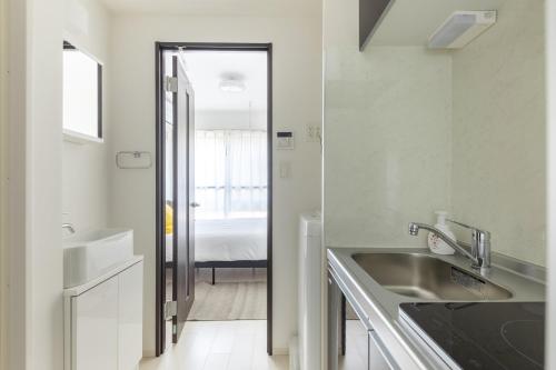 a white kitchen with a sink and a bathroom at 67 Apt Koenji Tokyo in Tokyo