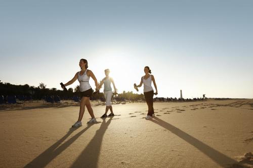 three women are walking on the beach at ROBINSON JANDIA PLAYA - Adults only in Morro del Jable
