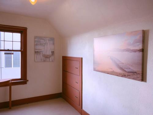 ein Schlafzimmer mit einer Kommode und einem Wandgemälde in der Unterkunft Seattle Urban Village- Shasta in Seattle