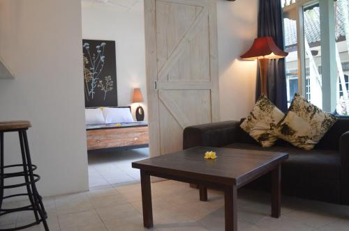 a living room with a couch and a table at Little Pond Homestay in Sanur