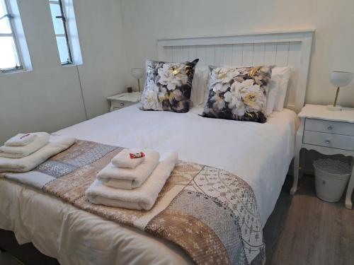 a bedroom with a bed with towels on it at The Muscadel in Paarl
