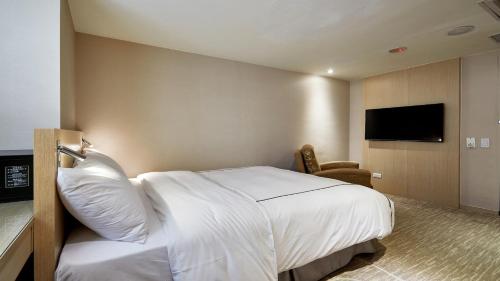 a hotel room with a bed and a television at K Hotel Taipei in Taipei