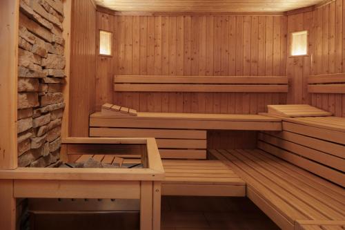 a sauna with wooden panels and a brick wall at Aparthotel Familiaris - Family Apartments - Pools & Spa in Dolomites in Valdaora