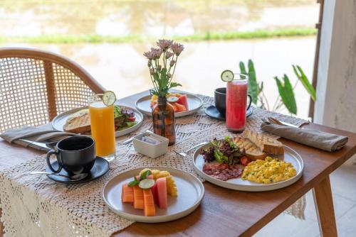 a table with plates of breakfast food on it at Villa Rabita in Ubud