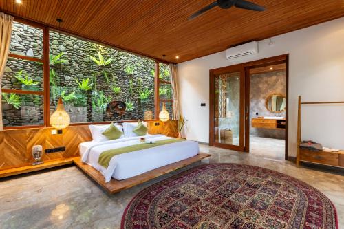 - une chambre avec un grand lit et une grande fenêtre dans l'établissement Villa Rabita, à Ubud