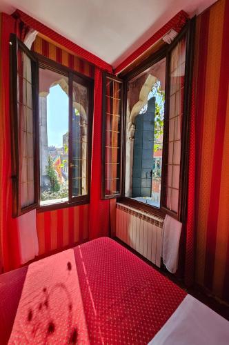 a red room with two windows and a red tub at Messner Palace in Venice