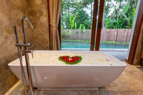a bath tub with a heart in the middle at Villa Rabita in Ubud