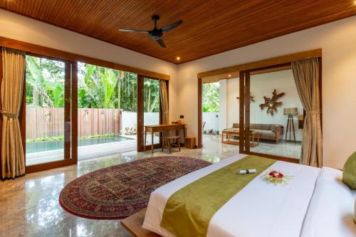 a bedroom with a large bed and a large window at Villa Rabita in Ubud