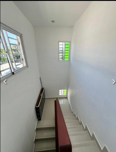a staircase in a white room with two windows at Lagrande Home in La Grúa