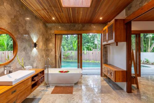 La salle de bains est pourvue d'une baignoire et d'un lavabo. dans l'établissement Villa Rabita, à Ubud