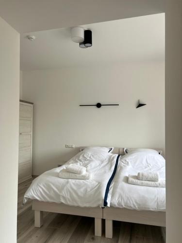 a white bedroom with a bed with two towels on it at Apartment Am Weißenberg 2 in Neuhofen an der Krems