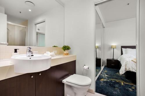 1 cama y baño con lavabo y aseo. en Absolute Waterfront - Enjoy Exceptional Lifestyle, en Cairns