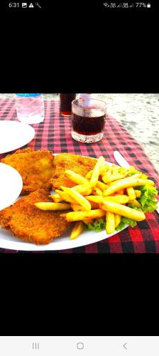 a plate of food with french fries on a table at Fernandes Bar and Restaurant in Canacona