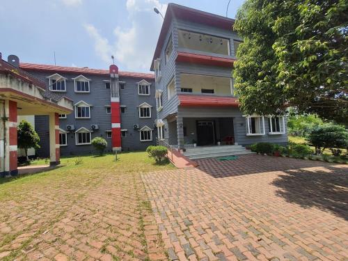 a brick driveway in front of a building at Lake Side Resort Neermahal in Melāghar