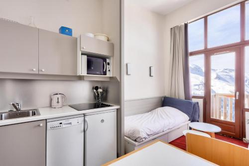 une petite cuisine avec une table et une fenêtre dans l'établissement Résidence Antarès - maeva Home - Appartement 2 pièces 4 personnes - Sélection MAE-4214, à Avoriaz