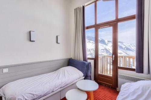 a room with a bed and a window with mountains at Résidence Antarès - maeva Home - Appartement 2 pièces 4 personnes - Prest 214 in Avoriaz
